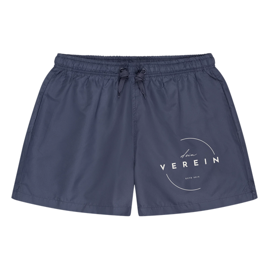 Blaue Badeshorts mit elastischem Bund und Kordelzug. Auf dem Bein ist das Vereinslogo mit dem Schriftzug ‚dein Verein – estd 2018‘ abgebildet. Der Vereinsname kann individuell angepasst werden