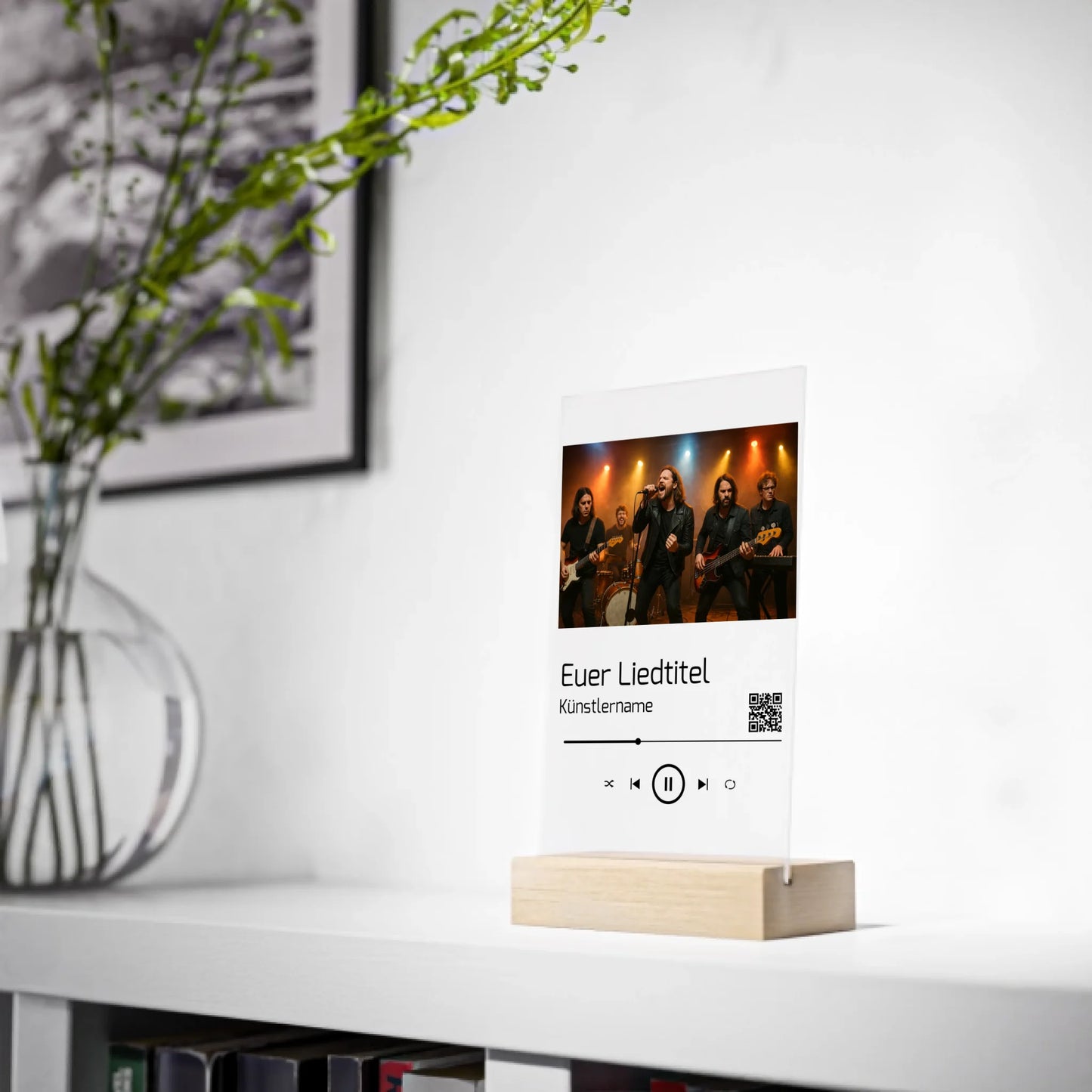 Dekorative Acrylplatte in Holzständer mit aufgedrucktem Bandfoto auf einer Bühne. Darunter ist ein individueller Songtitel, Künstlername und ein QR-Code abgebildet der direkt zu Spotify führt. Das Design erinnert an einen Musik-Player und kann mit eigenem Foto, Liedtitel und Namen personalisiert werden.