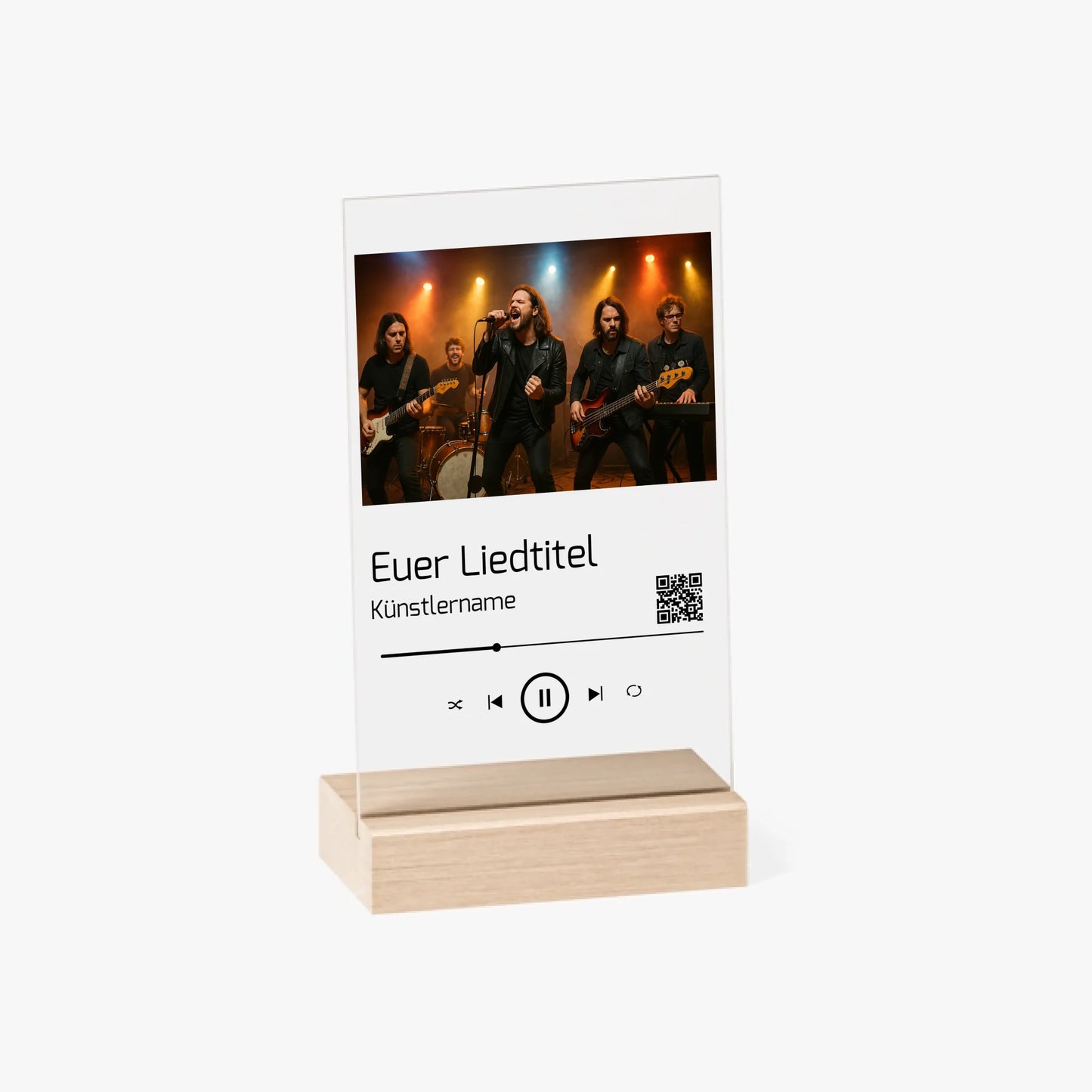 Dekorative Acrylplatte in Holzständer mit aufgedrucktem Bandfoto auf einer Bühne. Darunter ist ein individueller Songtitel, Künstlername und ein QR-Code abgebildet der direkt zu Spotify führt. Das Design erinnert an einen Musik-Player und kann mit eigenem Foto, Liedtitel und Namen personalisiert werden.