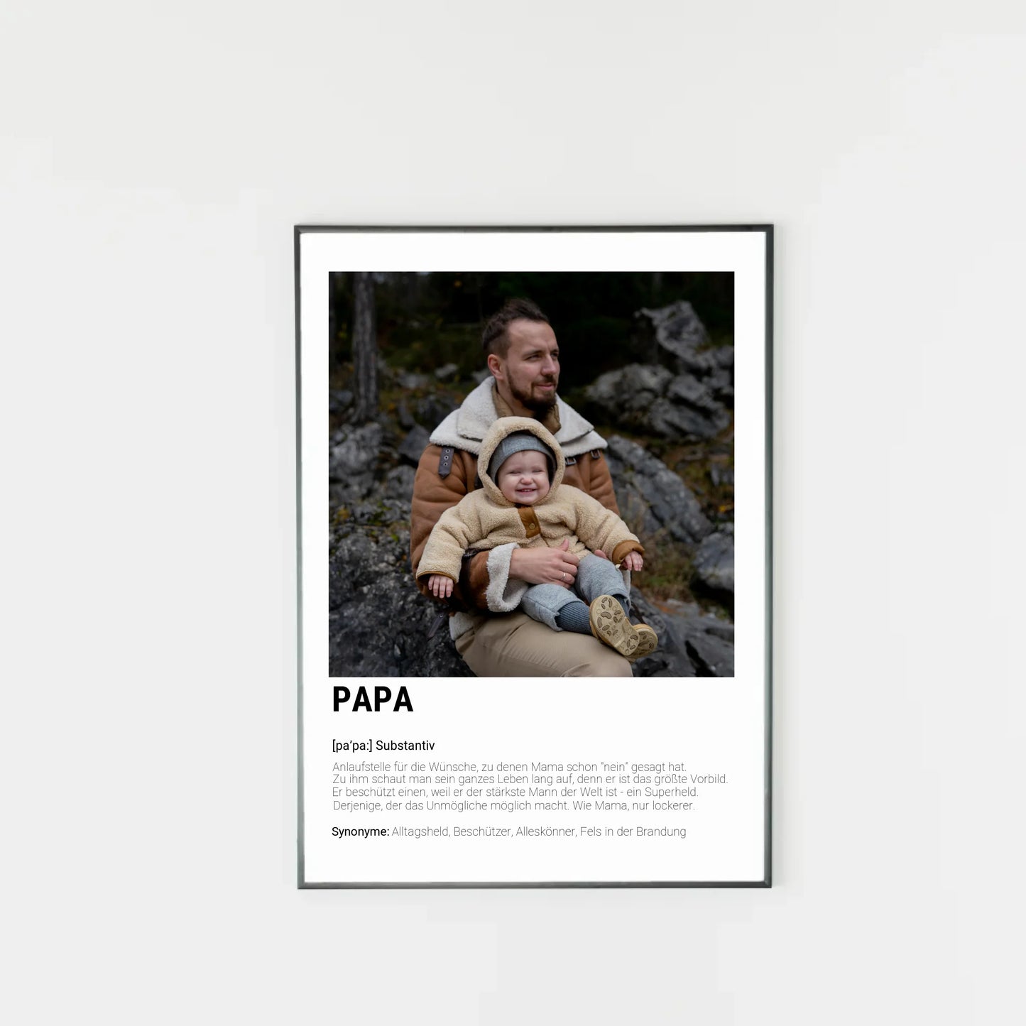 Poster mit personalisierbarem Foto-Bereich im oberen Teil in einem dunklen Holzrahmem. Darunter steht groß das Wort ‚PAPA‘ mit einer Definition in Wörterbuch-Stil. Beschrieben wird der Vater als Alltagsheld, Beschützer, Alleskönner und Fels in der Brandung
