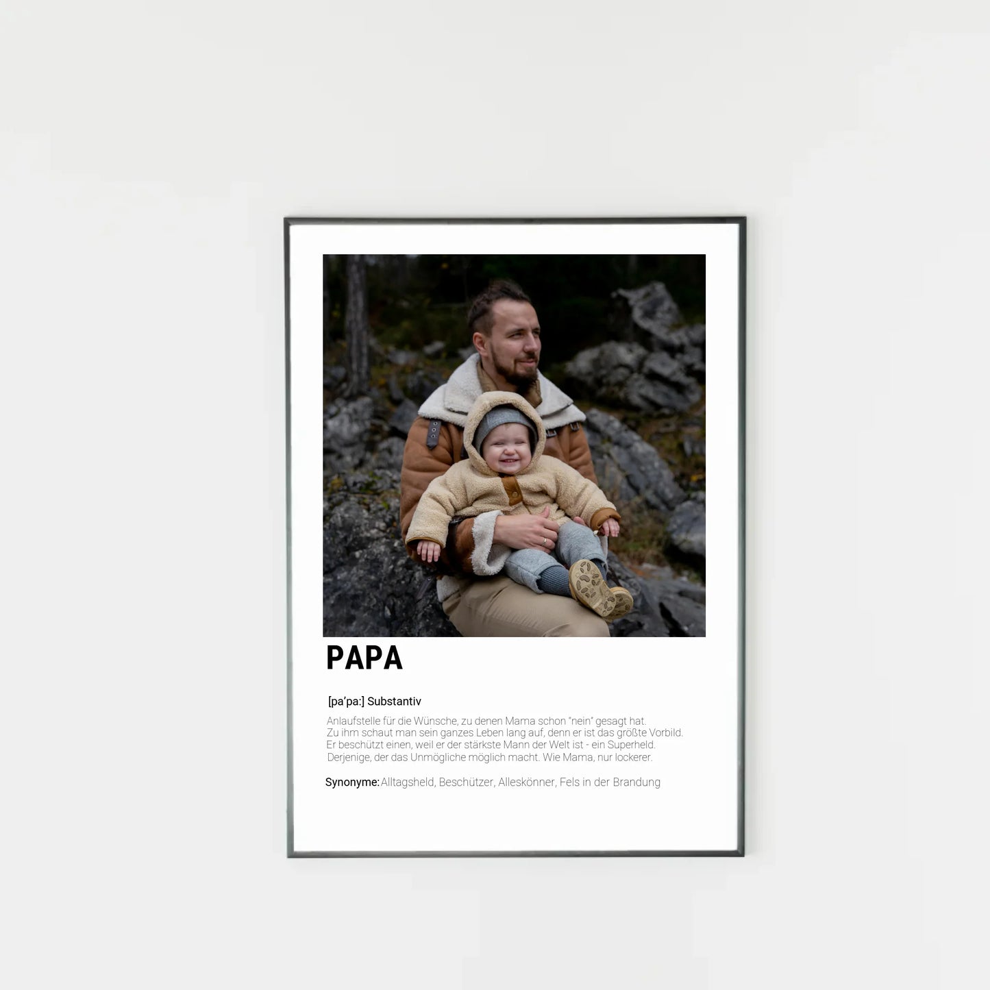 Poster mit personalisierbarem Foto-Bereich im oberen Teil in einem dunklen Holzrahmem. Darunter steht groß das Wort ‚PAPA‘ mit einer Definition in Wörterbuch-Stil. Beschrieben wird der Vater als Alltagsheld, Beschützer, Alleskönner und Fels in der Brandung