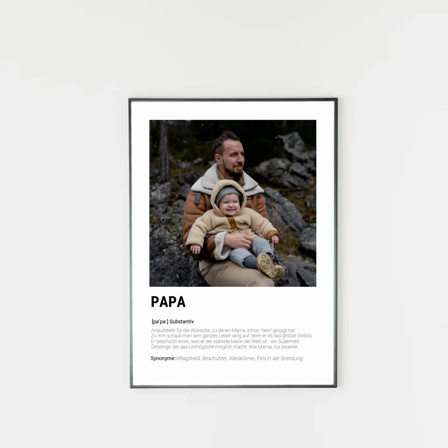 Poster mit personalisierbarem Foto-Bereich im oberen Teil in einem dunklen Holzrahmem. Darunter steht groß das Wort ‚PAPA‘ mit einer Definition in Wörterbuch-Stil. Beschrieben wird der Vater als Alltagsheld, Beschützer, Alleskönner und Fels in der Brandung