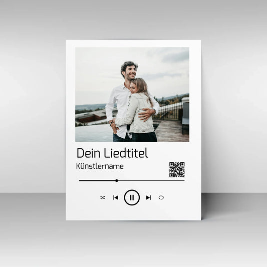 Poster im Stil einer Musik-App mit personalisierbarem Foto oben. Darunter Platz für individuellen Liedtitel, Künstlername und einen QR-Code, der direkt zu Spotify führt. Unten grafische Symbole einer Musiksteuerung wie Play, Pause und Skip.