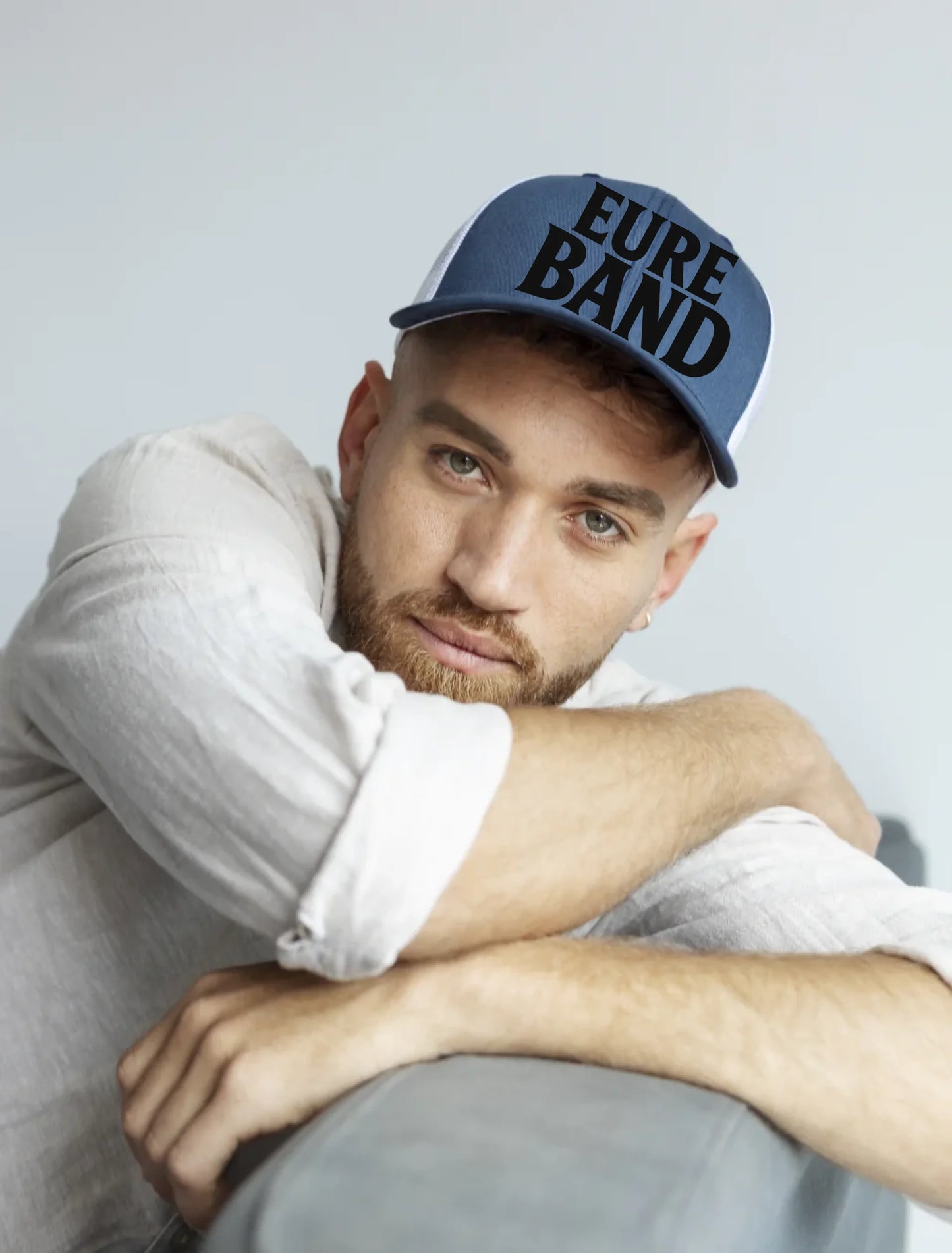 Basecap in Blau und Weiß mit dem Aufdruck ‚Eure Band‘ auf der Vorderseite. Der Schriftzug kann individuell mit dem eigenen Bandnamen gestaltet werden.
