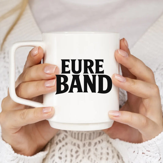 Weiße Keramiktasse mit großem schwarzen Schriftzug ‚Eure Band‘ auf der Vorderseite. Der Text kann individuell mit dem eigenen Bandnamen gestaltet werden.