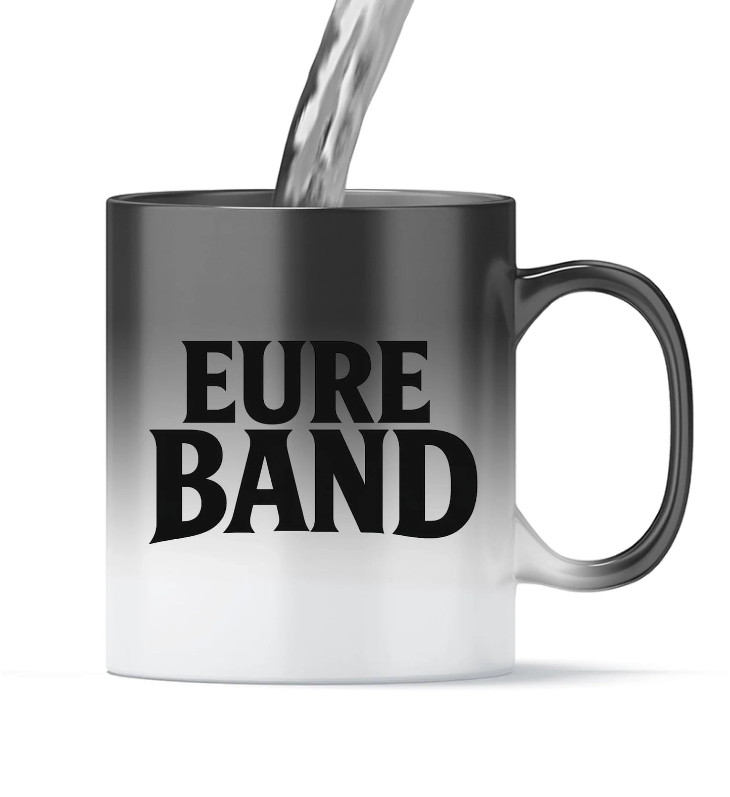Zaubertasse, bei der sich das Design durch warme Flüssigkeit sichtbar entfaltet. Auf der Vorderseite erscheint der schwarze Schriftzug ‚Eure Band‘. Der Aufdruck kann individuell mit dem eigenen Bandnamen gestaltet werden.
