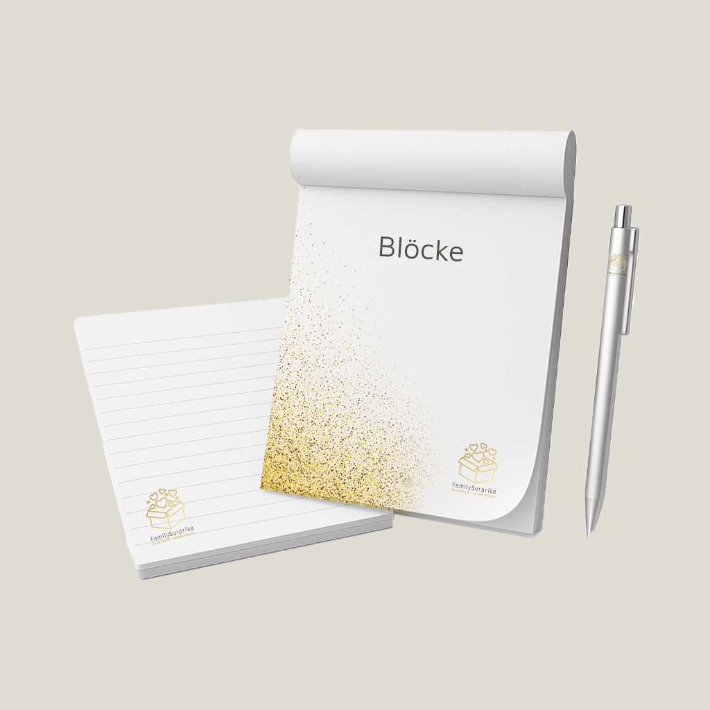 Notizblöcke mit „FamilySurprise“-Logo, darunter ein liniertes Blatt sowie ein Stift daneben.
