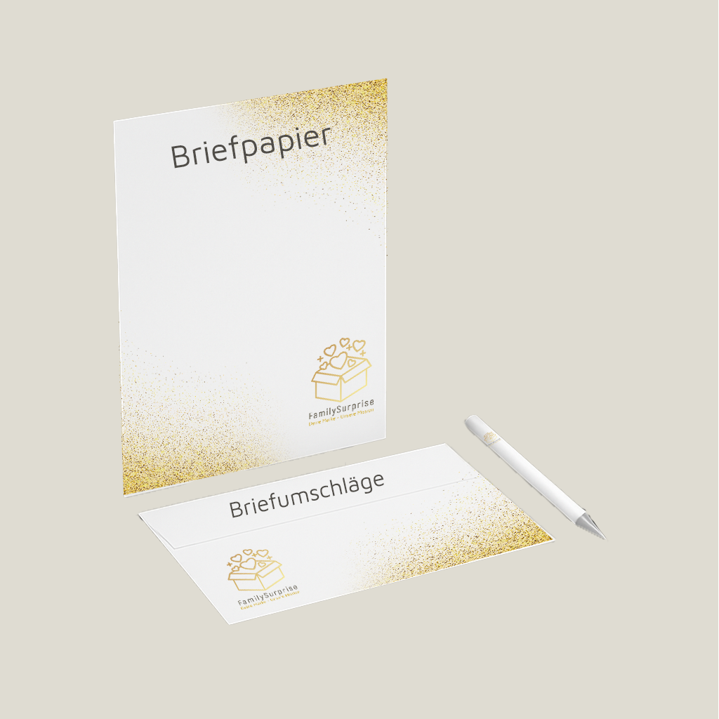 Briefpapier und ein passender Briefumschlag mit „FamilySurprise“-Logo und goldfarbenem Verlauf, daneben ein Stift.