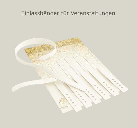 Weiße Einlassbänder mit Lochungen und aufgedrucktem „FamilySurprise“-Logo, fächerförmig ausgebreitet.