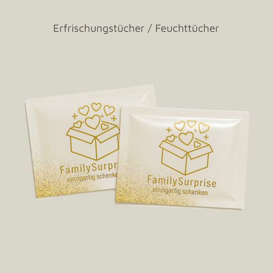Zwei einzeln verpackte Erfrischungs- bzw. Feuchttücher mit „FamilySurprise“-Logo und goldener Gestaltung.