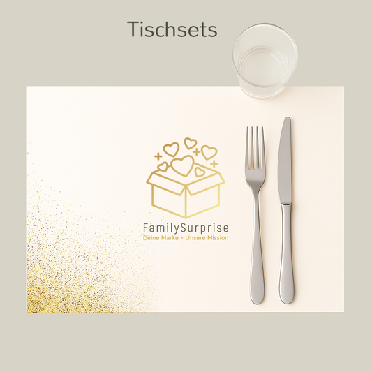 Tischset mit dem goldfarbenen „FamilySurprise“-Logo, ergänzt durch Besteck und Becher, auf einem Bildschirm dargestellt.