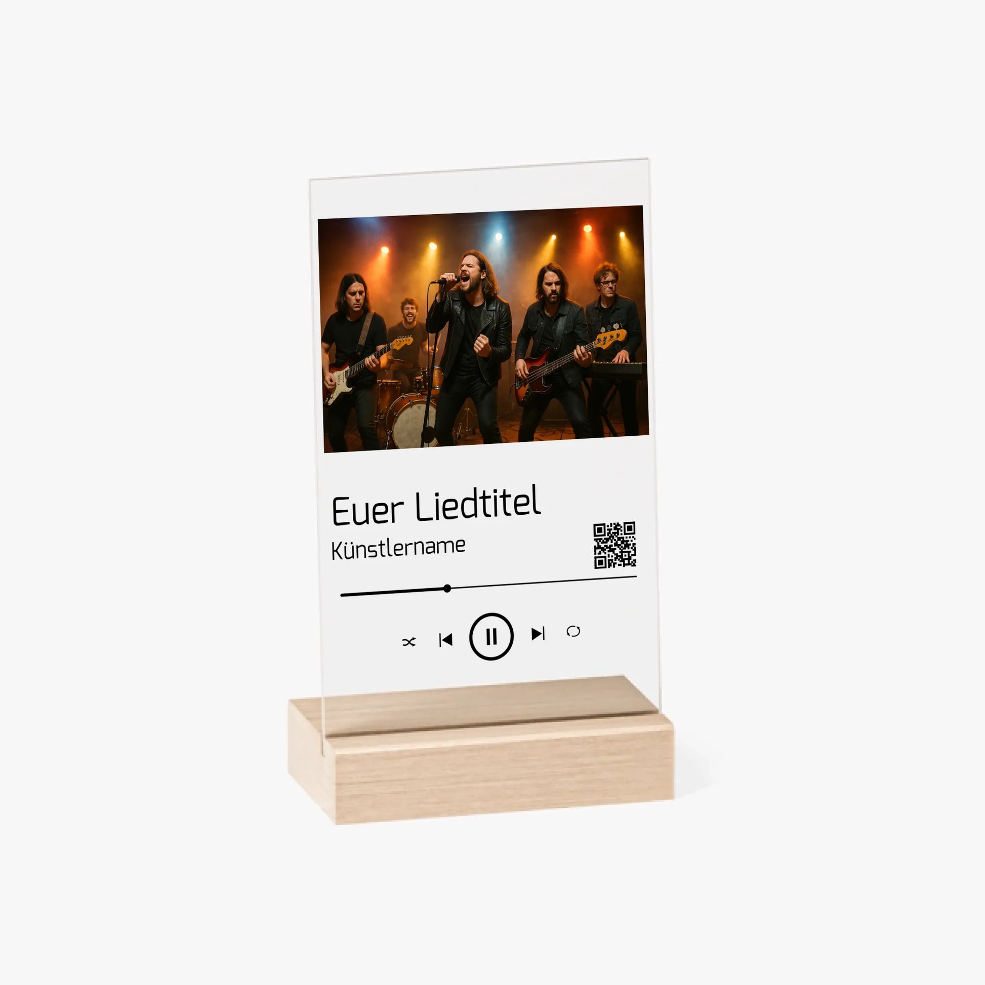 Dekorative Acrylplatte in Holzständer mit aufgedrucktem Bandfoto auf einer Bühne. Darunter ist ein individueller Songtitel, Künstlername und ein QR-Code abgebildet der direkt zu Spotify führt. Das Design erinnert an einen Musik-Player und kann mit eigenem Foto, Liedtitel und Namen personalisiert werden.