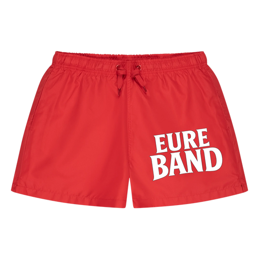 Rote Badeshorts mit elastischem Bund und Kordelzug. Auf dem Bein steht der weiße Schriftzug ‚Eure Band‘. Der Aufdruck kann individuell mit dem eigenen Bandnamen gestaltet werden