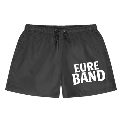 Schwarze Badeshorts mit elastischem Bund und Kordelzug. Auf dem Bein steht der weiße Schriftzug ‚Eure Band‘. Der Aufdruck kann individuell mit dem eigenen Bandnamen gestaltet werden