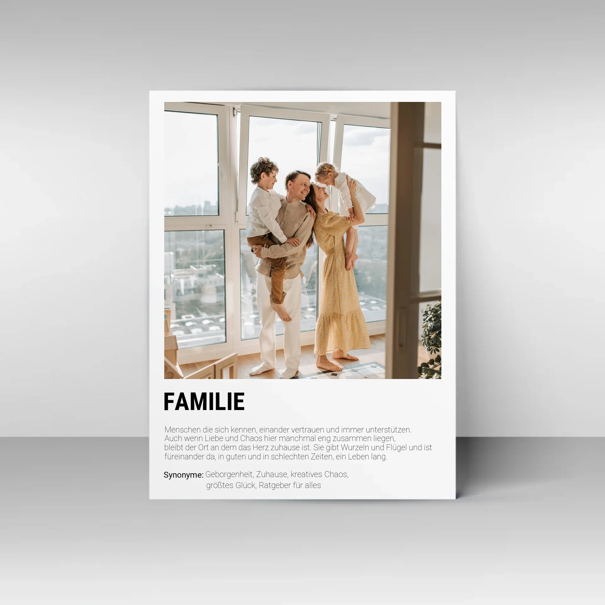 Poster mit personalisierbarem Foto. Unten groß ‚FAMILIE‘ mit Definition im Wörterbuchstil: Menschen, die sich kennen, vertrauen, unterstützen und gemeinsam durch Liebe und Chaos gehen. Familie gibt Wurzeln und Flügel, ist immer da – in guten wie in schlechten Zeiten. Synonyme: Geborgenheit, Zuhause, kreatives Chaos, größtes Glück, Ratgeber für alles.