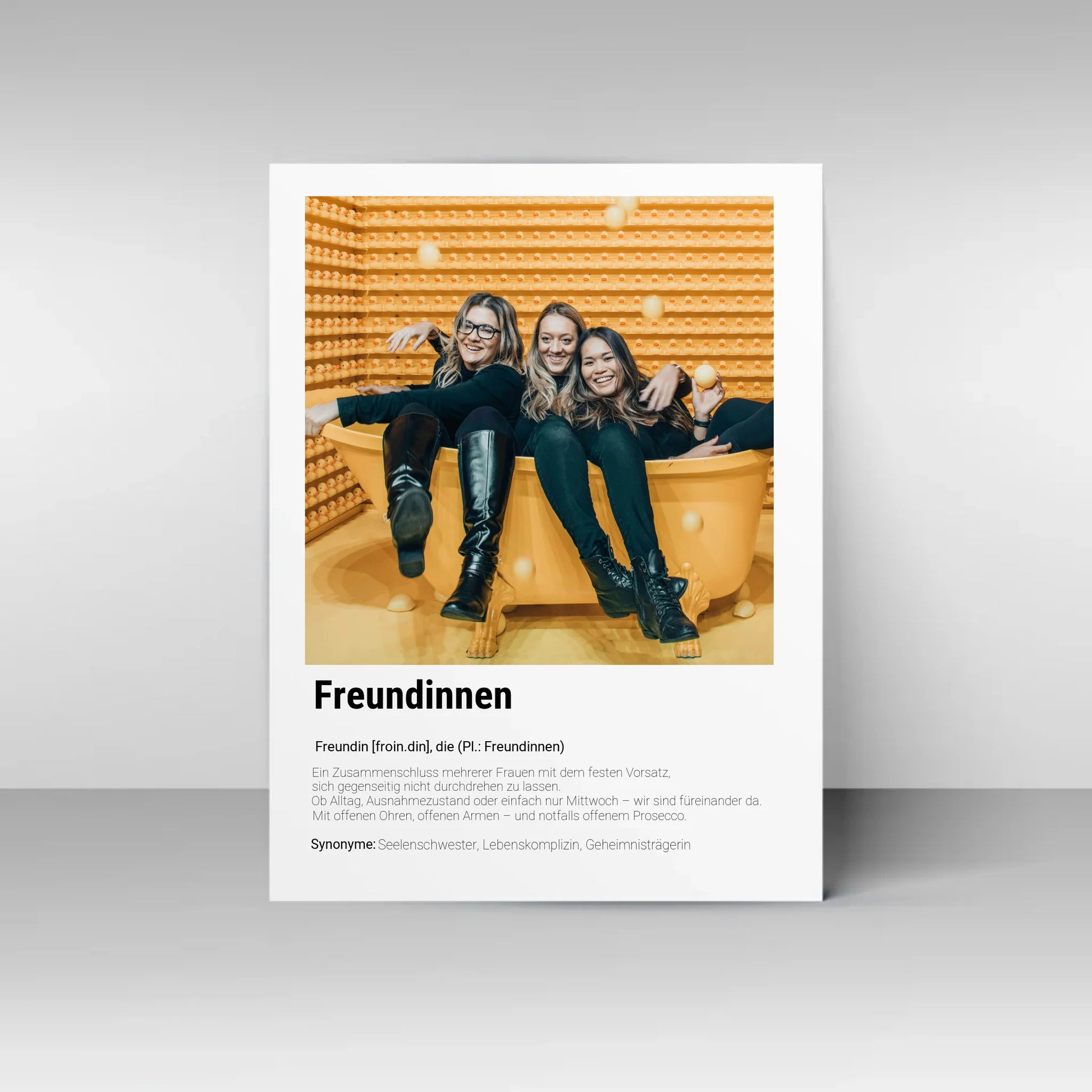 Poster mit personalisierbarem Foto. Unten groß ‚Freundinnen‘ mit Definition im Wörterbuchstil: Zusammenschluss mehrerer Frauen, die sich gegenseitig unterstützen – im Alltag, im Ausnahmezustand oder einfach am Mittwoch. Immer da mit offenen Ohren, offenen Armen und notfalls auch Prosecco. Synonyme: Seelenschwester, Lebenskomplizin, Geheimnisträgerin.