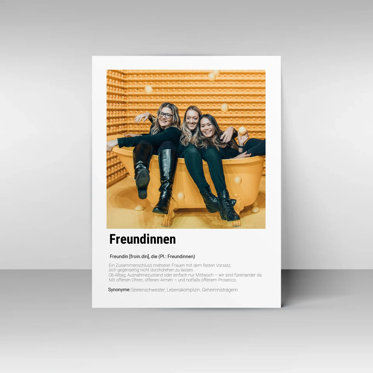 Poster mit personalisierbarem Foto. Unten groß ‚Freundinnen‘ mit Definition im Wörterbuchstil: Zusammenschluss mehrerer Frauen, die sich gegenseitig unterstützen – im Alltag, im Ausnahmezustand oder einfach am Mittwoch. Immer da mit offenen Ohren, offenen Armen und notfalls auch Prosecco. Synonyme: Seelenschwester, Lebenskomplizin, Geheimnisträgerin.