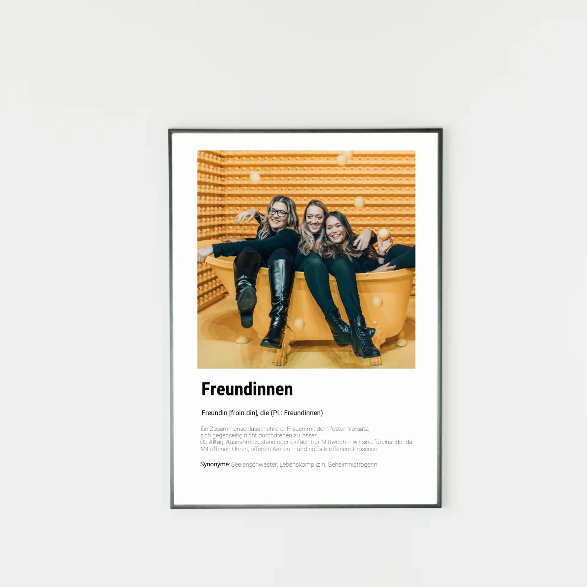 Poster mit personalisierbarem Foto. Unten groß ‚Freundinnen‘ mit Definition im Wörterbuchstil: Zusammenschluss mehrerer Frauen, die sich gegenseitig unterstützen – im Alltag, im Ausnahmezustand oder einfach am Mittwoch. Immer da mit offenen Ohren, offenen Armen und notfalls auch Prosecco. Synonyme: Seelenschwester, Lebenskomplizin, Geheimnisträgerin.