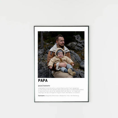 Poster mit personalisierbarem Foto-Bereich im oberen Teil in einem dunklen Holzrahmem. Darunter steht groß das Wort ‚PAPA‘ mit einer Definition in Wörterbuch-Stil. Beschrieben wird der Vater als Alltagsheld, Beschützer, Alleskönner und Fels in der Brandung