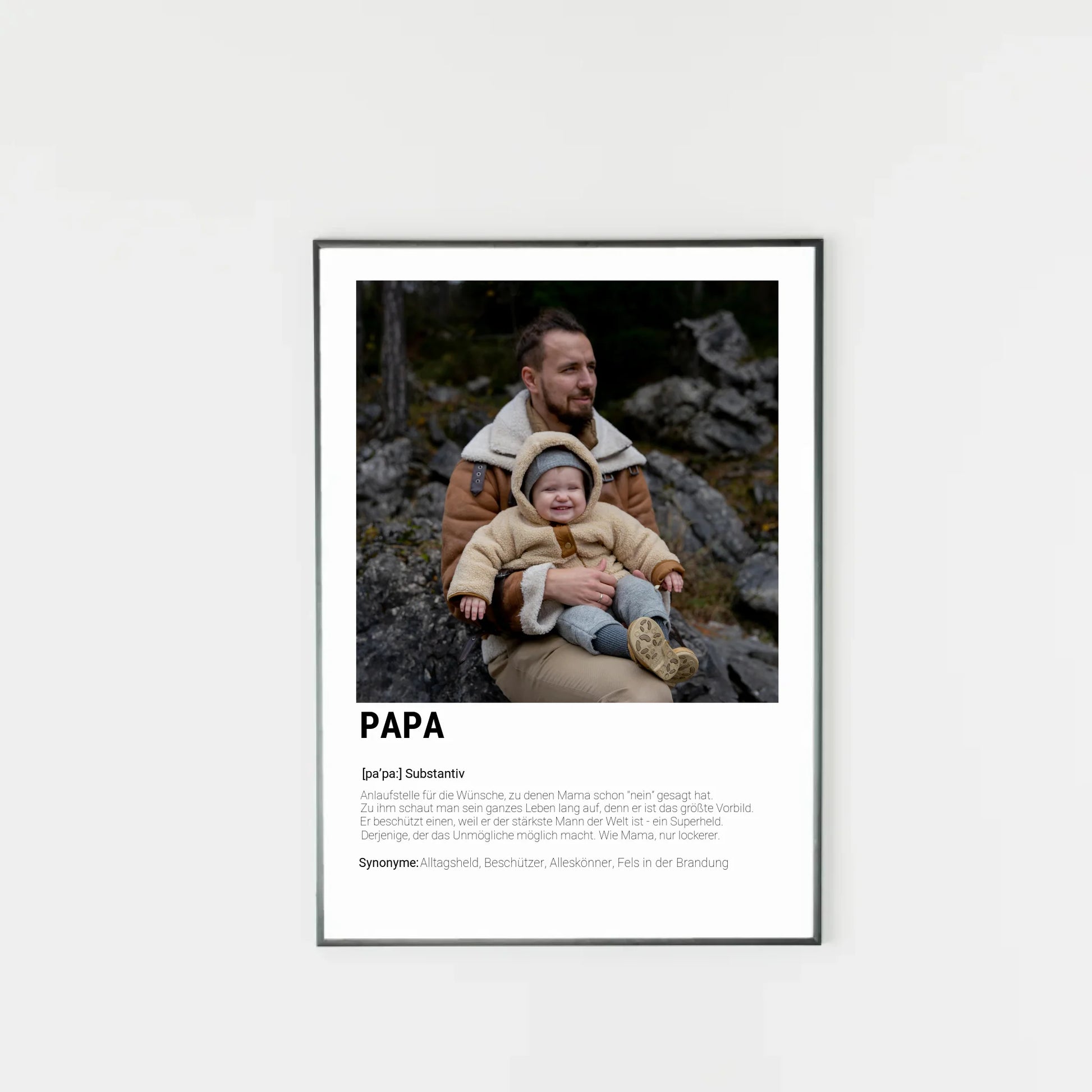 Poster mit personalisierbarem Foto-Bereich im oberen Teil in einem dunklen Holzrahmem. Darunter steht groß das Wort ‚PAPA‘ mit einer Definition in Wörterbuch-Stil. Beschrieben wird der Vater als Alltagsheld, Beschützer, Alleskönner und Fels in der Brandung
