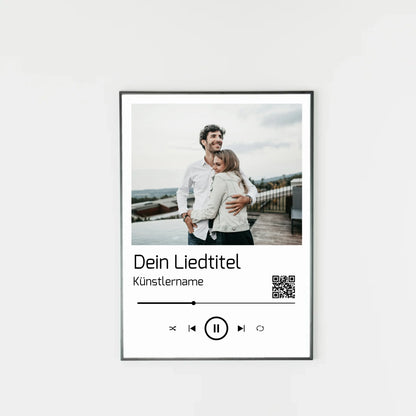 Poster im Stil einer Musik-App mit personalisierbarem Foto oben. Darunter Platz für individuellen Liedtitel, Künstlername und einen QR-Code, der direkt zu Spotify führt. Unten grafische Symbole einer Musiksteuerung wie Play, Pause und Skip.