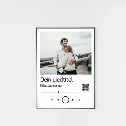 Poster im Stil einer Musik-App mit personalisierbarem Foto oben. Darunter Platz für individuellen Liedtitel, Künstlername und einen QR-Code, der direkt zu Spotify führt. Unten grafische Symbole einer Musiksteuerung wie Play, Pause und Skip.