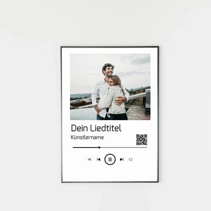 Poster im Stil einer Musik-App mit personalisierbarem Foto oben. Darunter Platz für individuellen Liedtitel, Künstlername und einen QR-Code, der direkt zu Spotify führt. Unten grafische Symbole einer Musiksteuerung wie Play, Pause und Skip.