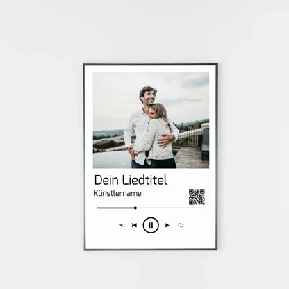 Poster im Stil einer Musik-App mit personalisierbarem Foto oben. Darunter Platz für individuellen Liedtitel, Künstlername und einen QR-Code, der direkt zu Spotify führt. Unten grafische Symbole einer Musiksteuerung wie Play, Pause und Skip.
