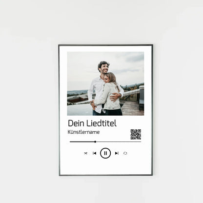 Poster im Stil einer Musik-App mit personalisierbarem Foto oben. Darunter Platz für individuellen Liedtitel, Künstlername und einen QR-Code, der direkt zu Spotify führt. Unten grafische Symbole einer Musiksteuerung wie Play, Pause und Skip.