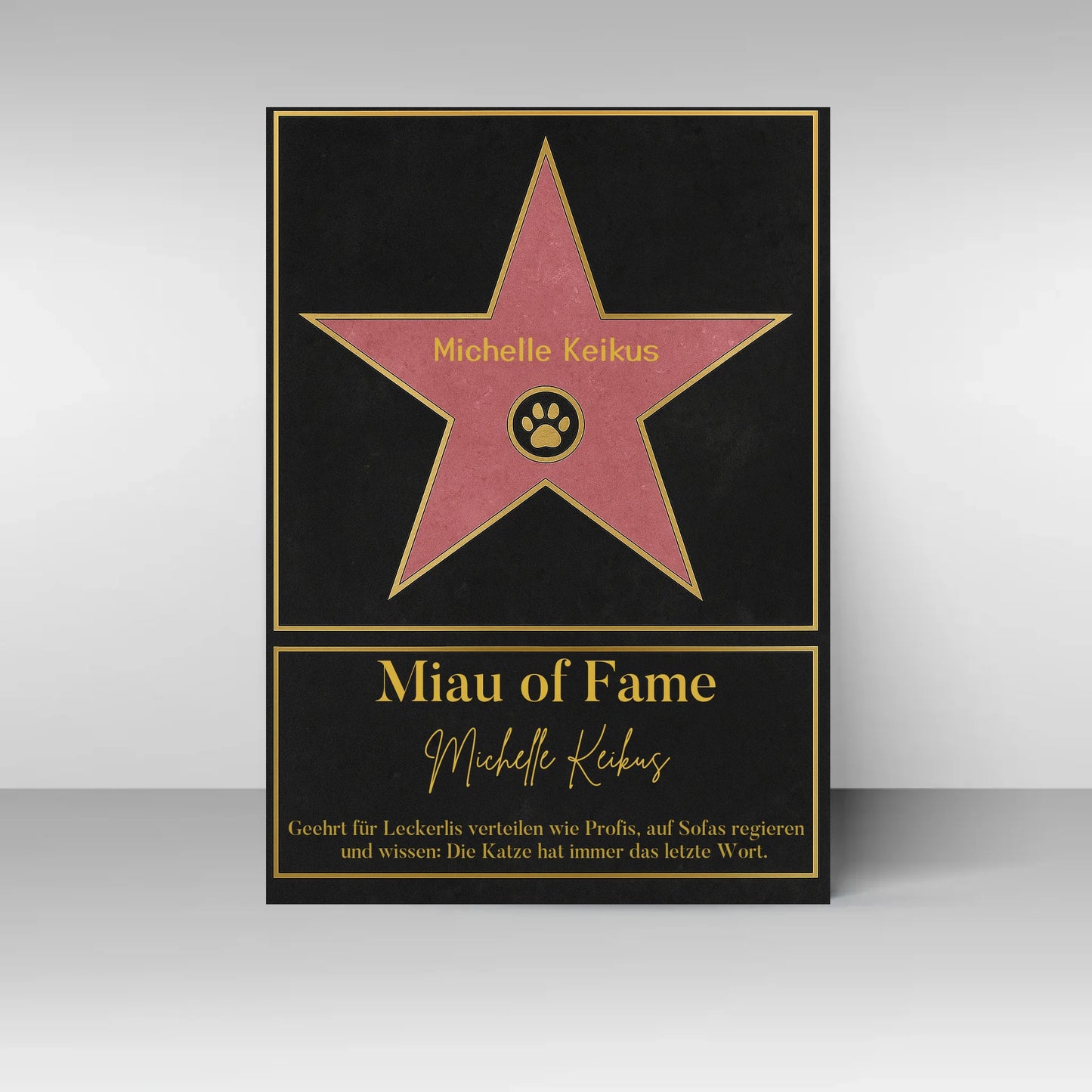 Poster im Stil eines ‚Walk of Fame‘-Sterns. In der Mitte ein rosa Stern mit gelbem Rand und Pfotenabdruck-Symbol, dazu ein personalisierbarer Name. Darunter der Titel ‚Miau of Fame‘ mit Namensfeld. Text: Geehrt für Leckerlis verteilen wie Profis, auf Sofas regieren und wissen: Die Katze hat immer das letzte Wort.