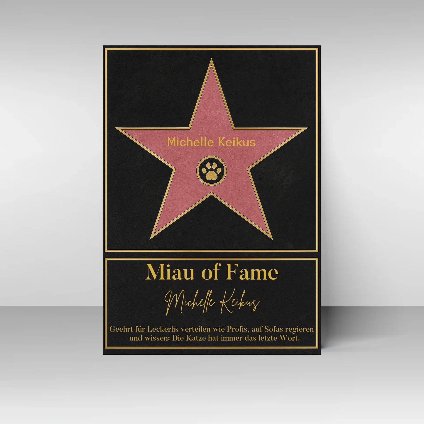 Poster im Stil eines ‚Walk of Fame‘-Sterns. In der Mitte ein rosa Stern mit gelbem Rand und Pfotenabdruck-Symbol, dazu ein personalisierbarer Name. Darunter der Titel ‚Miau of Fame‘ mit Namensfeld. Text: Geehrt für Leckerlis verteilen wie Profis, auf Sofas regieren und wissen: Die Katze hat immer das letzte Wort.