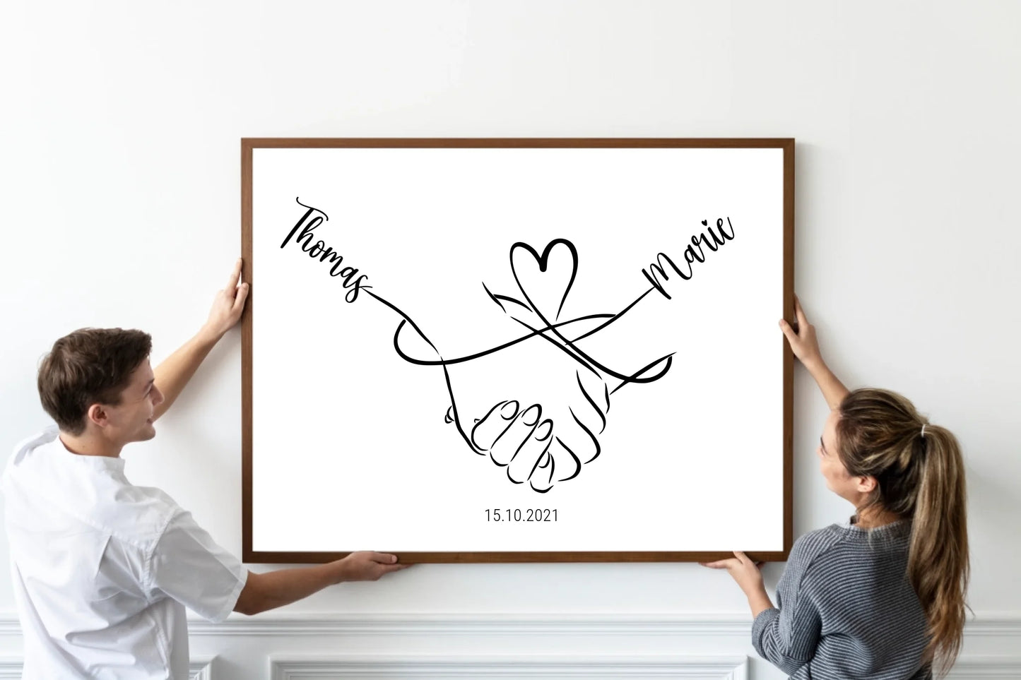 oster mit minimalistischer Zeichnung zweier Hände, die sich halten. Darüber eine geschwungene Linie in Herzform, links und rechts personalisierbare Namen. Unten Platz für ein Datum, hier als Beispiel 15.10.2021.