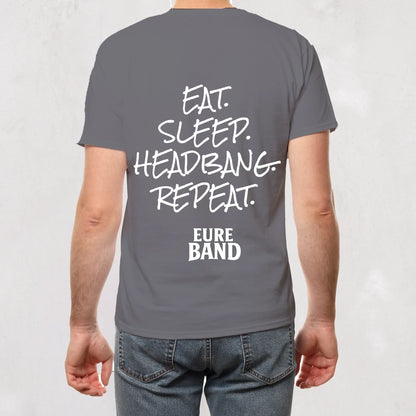 Graues T-Shirt mit großem weißen Aufdruck auf der Rückseite: ‚EAT. SLEEP. HEADBANG. REPEAT.‘ Darunter steht in weißen Buchstaben der Schriftzug ‚Eure Band‘. Der Bandname kann individuell angepasst werden.