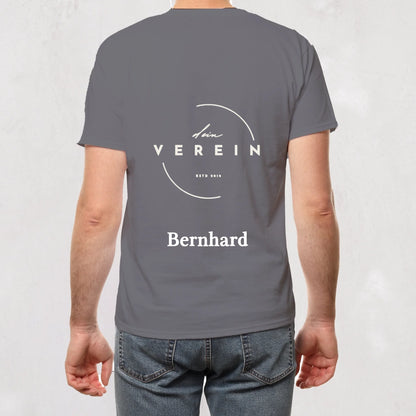graues T-Shirt mit Vereinslogo und dem Schriftzug ‚dein Verein – seit 2018‘ auf der Rückseite. Unterhalb des Logos steht ein personalisierbarer Name. Vereinsname und Name können individuell angepasst werden.