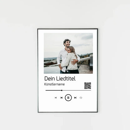 Poster im Stil einer Musik-App mit personalisierbarem Foto oben. Darunter Platz für individuellen Liedtitel, Künstlername und einen QR-Code, der direkt zu Spotify führt. Unten grafische Symbole einer Musiksteuerung wie Play, Pause und Skip.